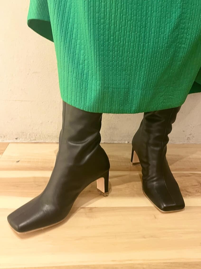 グリーン系のスカート、ブラック系のブーツ、ブラック系のTシャツ/カットソーを着用したレディースの夏コーディネートの8枚目の写真