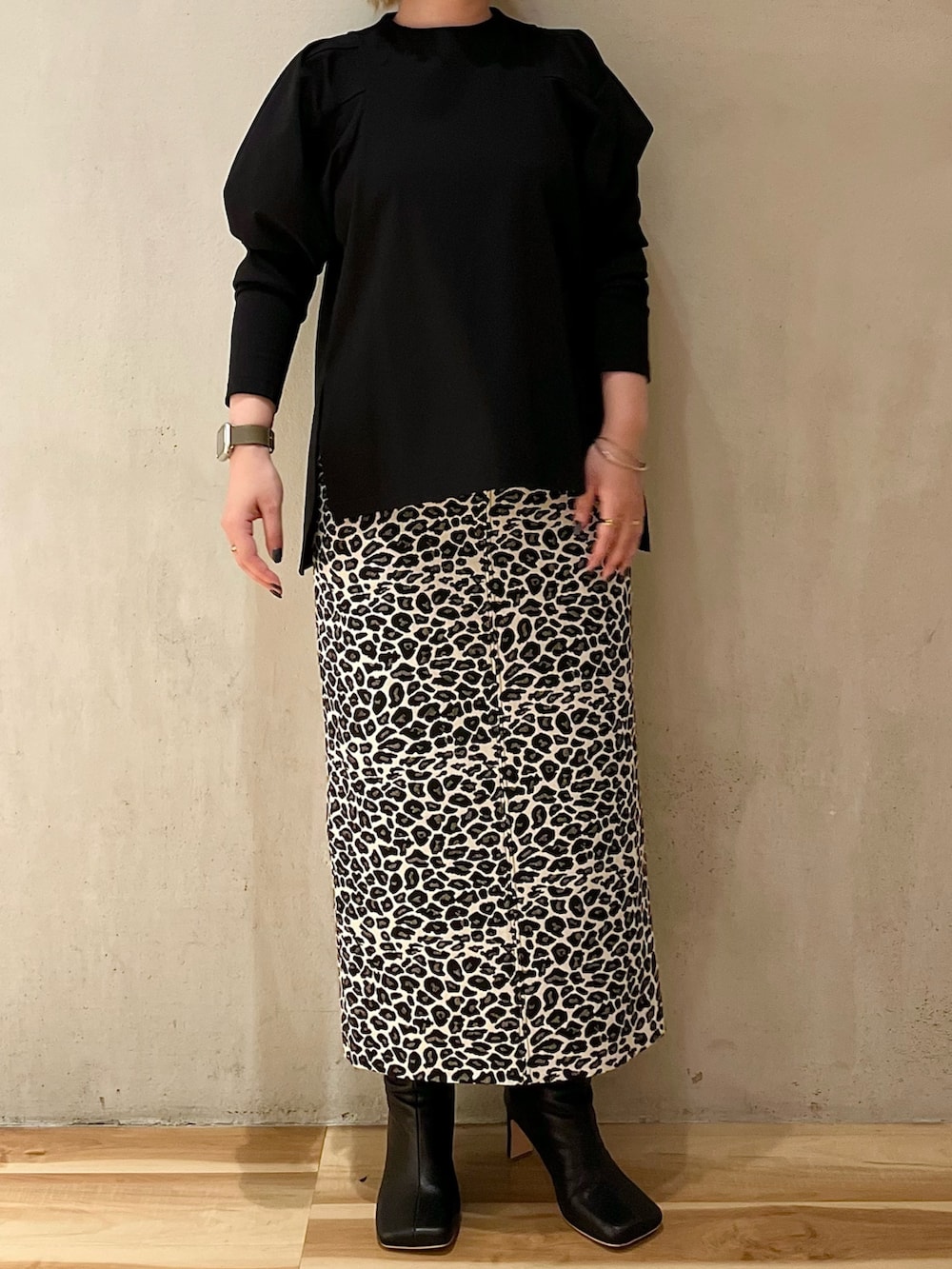 ブラック系のTシャツ/カットソー、ホワイト系のスカート、ブラック系のブーツを着用したレディースの春コーディネートの7枚目の写真