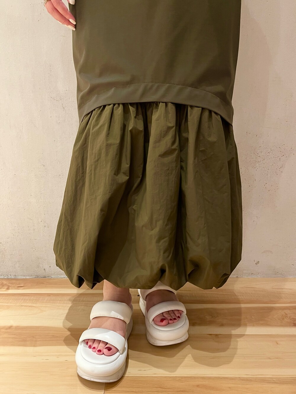 ホワイト系のサンダル、ホワイト系のブルゾン、グリーン系のワンピースを着用したレディースの冬コーディネートの8枚目の写真