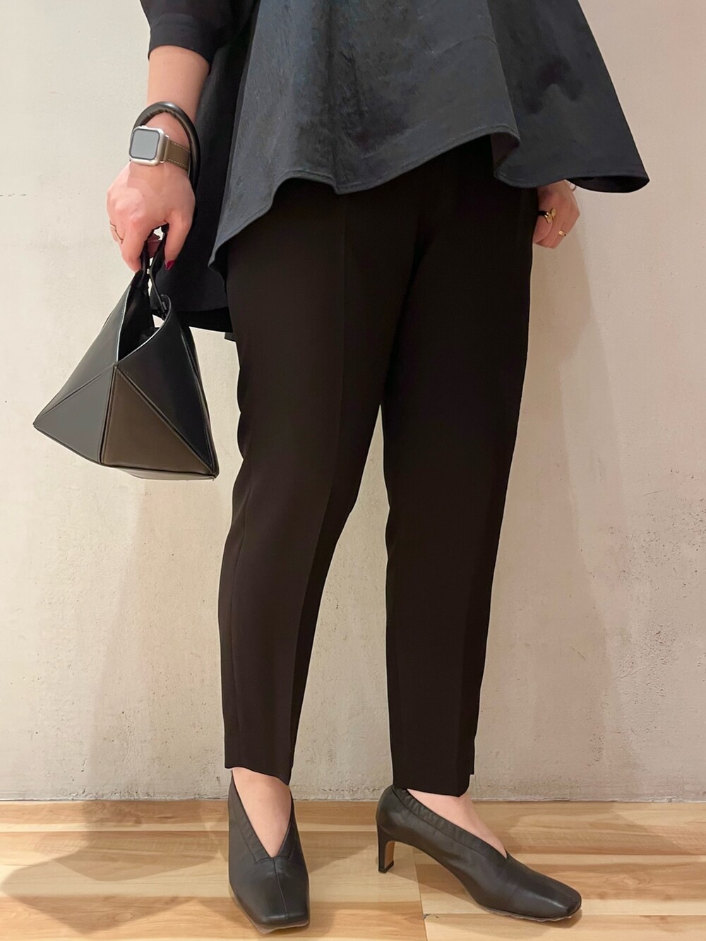 ブラック系のハンドバッグ、ブラック系のその他パンツ、ブラック系のシャツ/ブラウスを着用したレディースの冬コーディネートの8枚目の写真