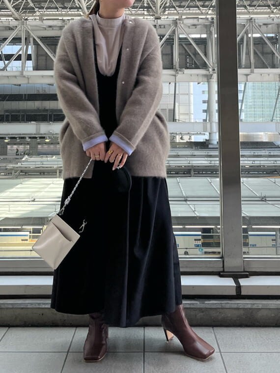 ブラック系のジャンパースカート、ホワイト系のショルダーバッグ、ベージュ系のシャツ/ブラウスを着用したレディースの夏コーディネートの5枚目の写真