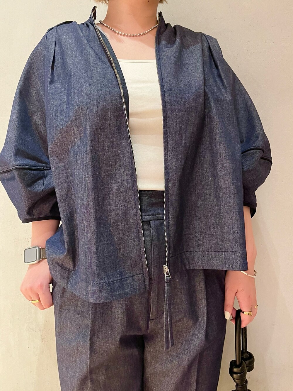 ブラック系のハンドバッグ、ブラック系のサンダル、ブルー系のブルゾンを着用したレディースの春コーディネートの4枚目の写真