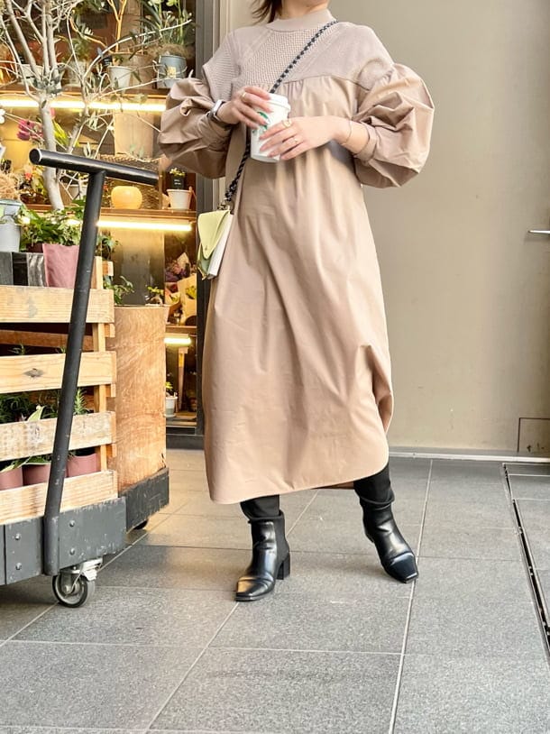 イエロー系のショルダーバッグ、ブラック系のブーツ、ベージュ系のワンピースを着用したレディースの冬コーディネートの4枚目の写真