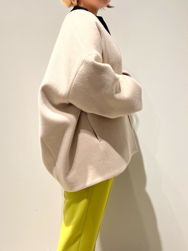 ブラック系のショルダーバッグ、グリーン系のその他パンツ、ベージュ系のノーカラーコートを着用したレディースの秋コーディネートの5枚目の写真