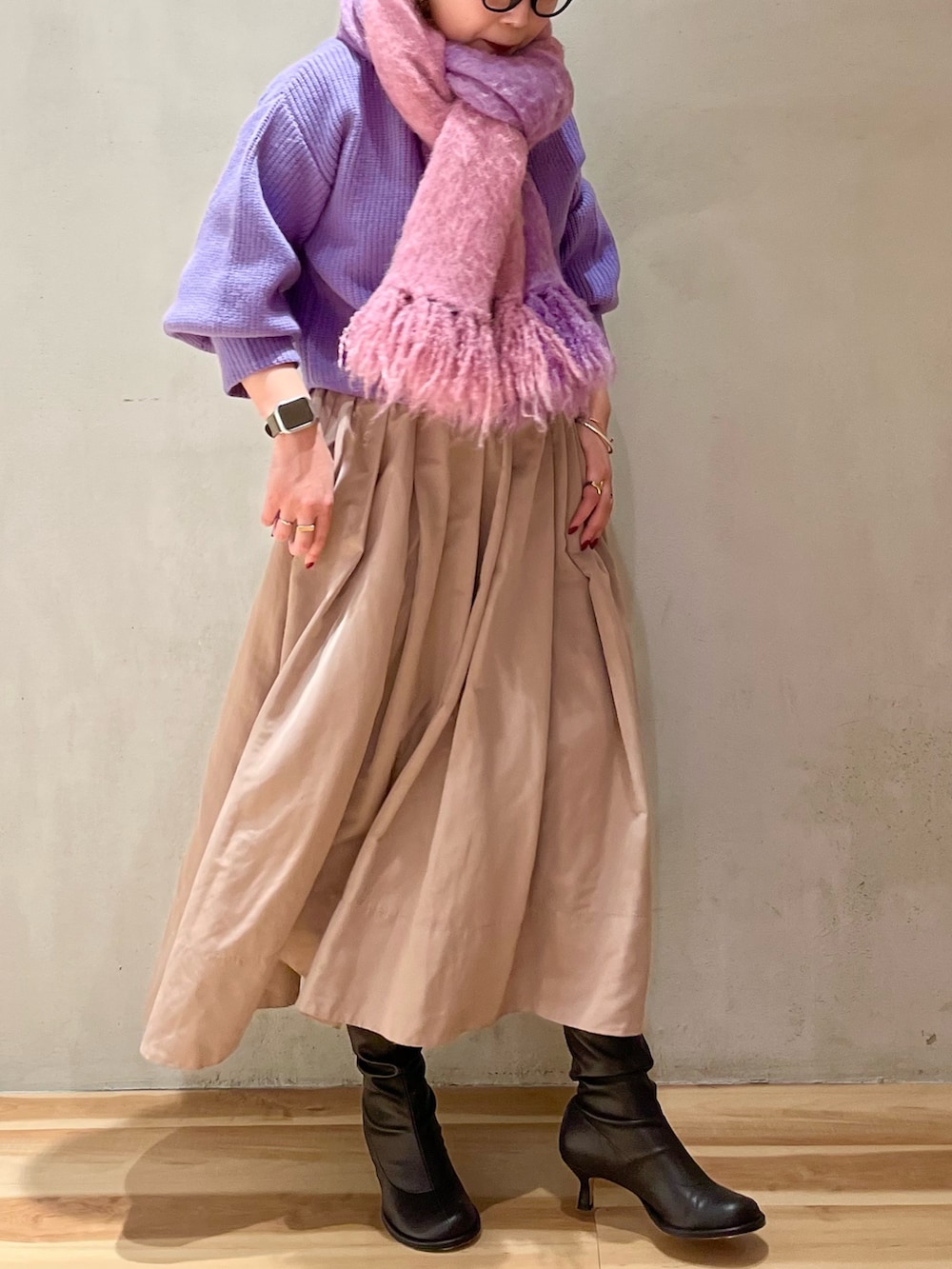 パープル系のニット/セーター、ベージュ系のスカート、パープル系のストール/ショールを着用したレディースの冬コーディネートの2枚目の写真