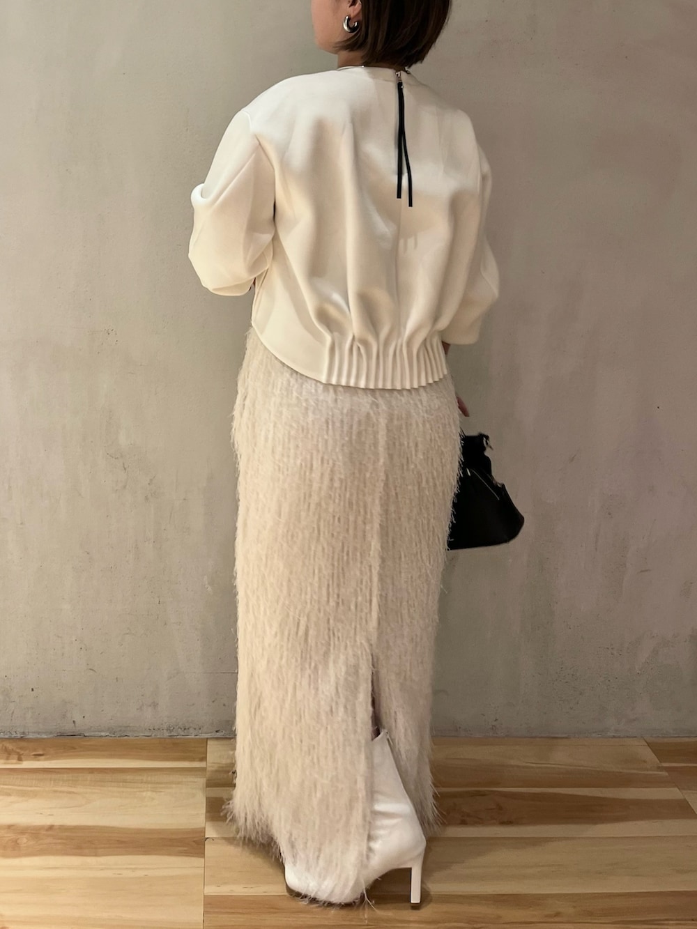 ホワイト系のTシャツ/カットソー、ホワイト系のスカート、ホワイト系のブーツを着用したレディースの春コーディネートの2枚目の写真