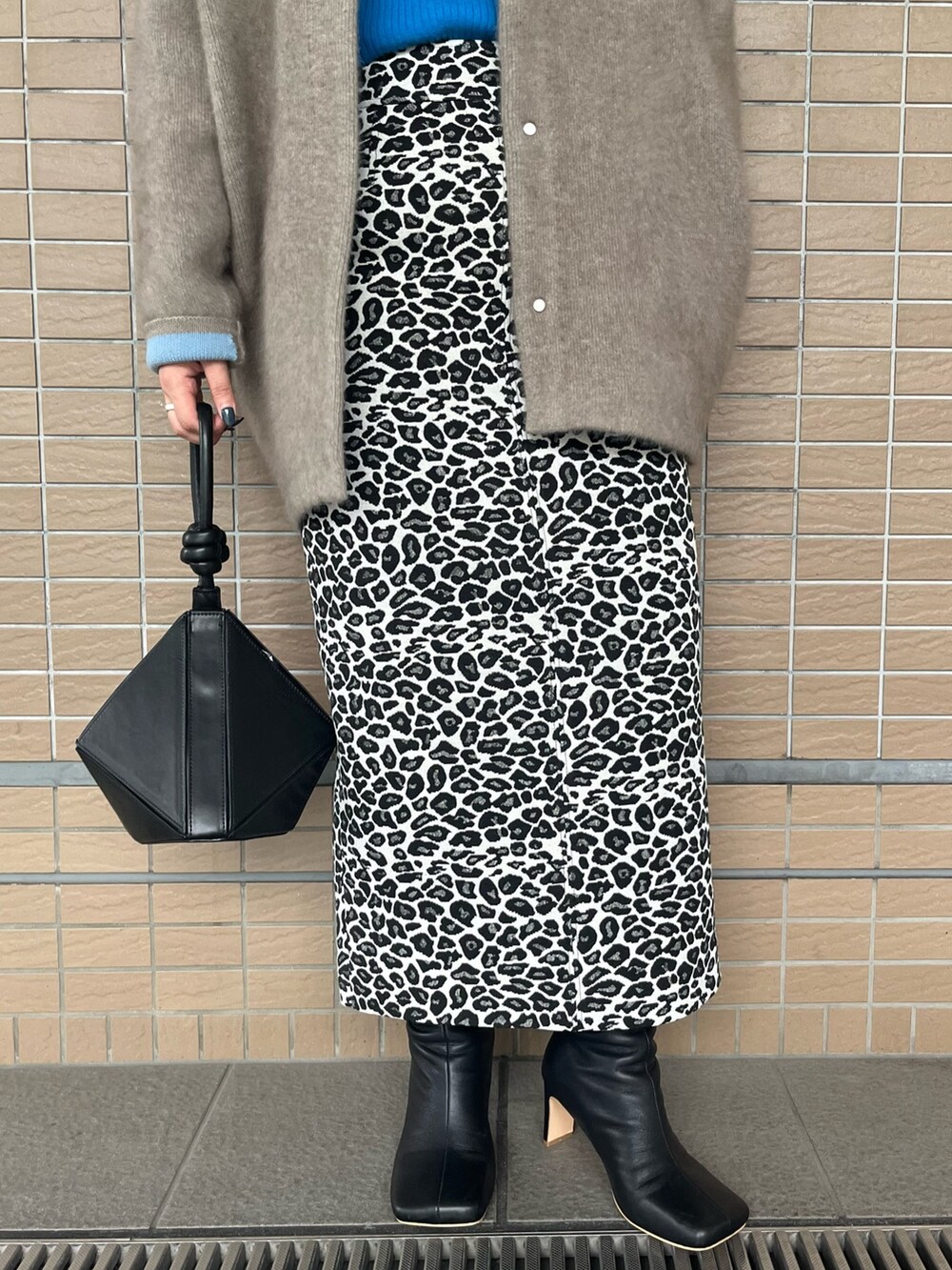 ベージュ系のノーカラージャケット、ブラック系のブーツ、ブラック系のハンドバッグを着用したレディースの夏コーディネートの7枚目の写真