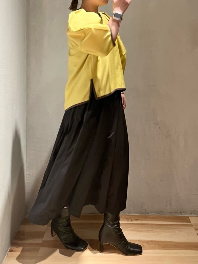 イエロー系のシャツ/ブラウス、ブラック系のスカート、ブラック系のブーツを着用したレディースの夏コーディネートの2枚目の写真