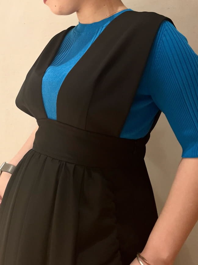 ブルー系のニット/セーター、ブラック系のジャンパースカート、ブラック系のブーツを着用したレディースの夏コーディネートの6枚目の写真