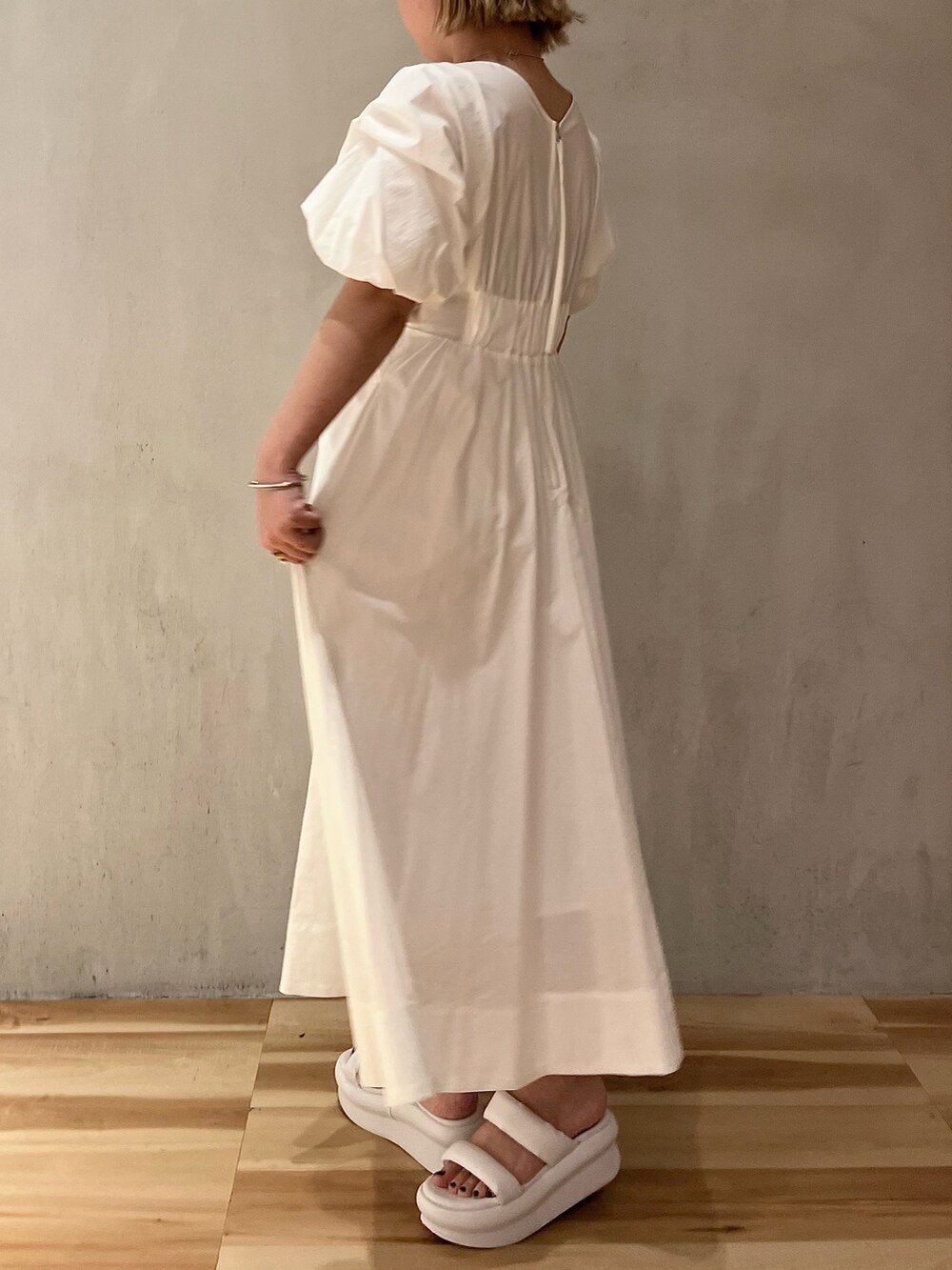 ホワイト系のワンピース、ホワイト系のサンダル、ホワイト系のハットを着用したレディースの春コーディネートの4枚目の写真