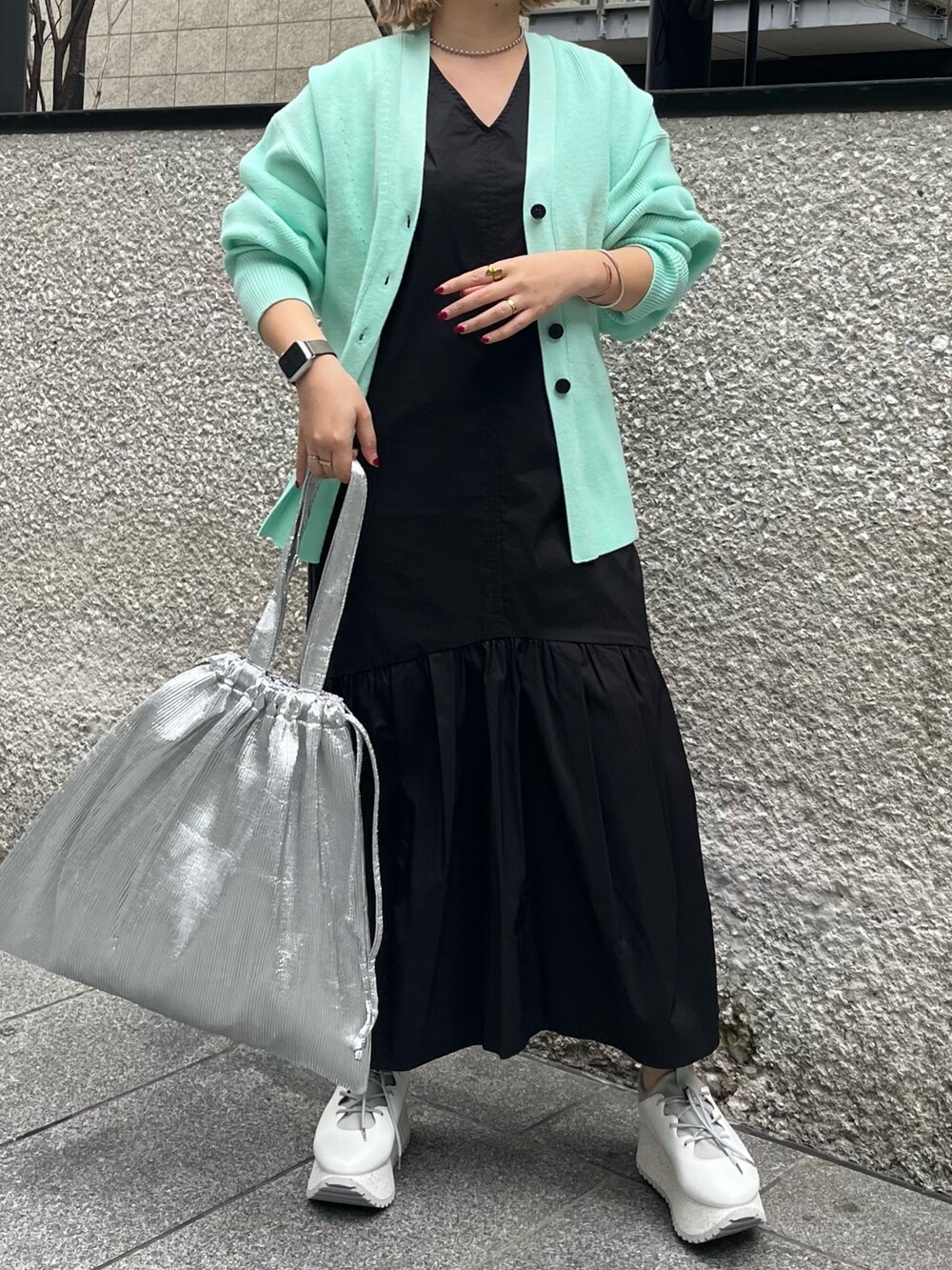 グリーン系のカーディガン/ボレロ、ブルー系のワンピース、シルバー系のトートバッグを着用したレディースの冬コーディネートの2枚目の写真