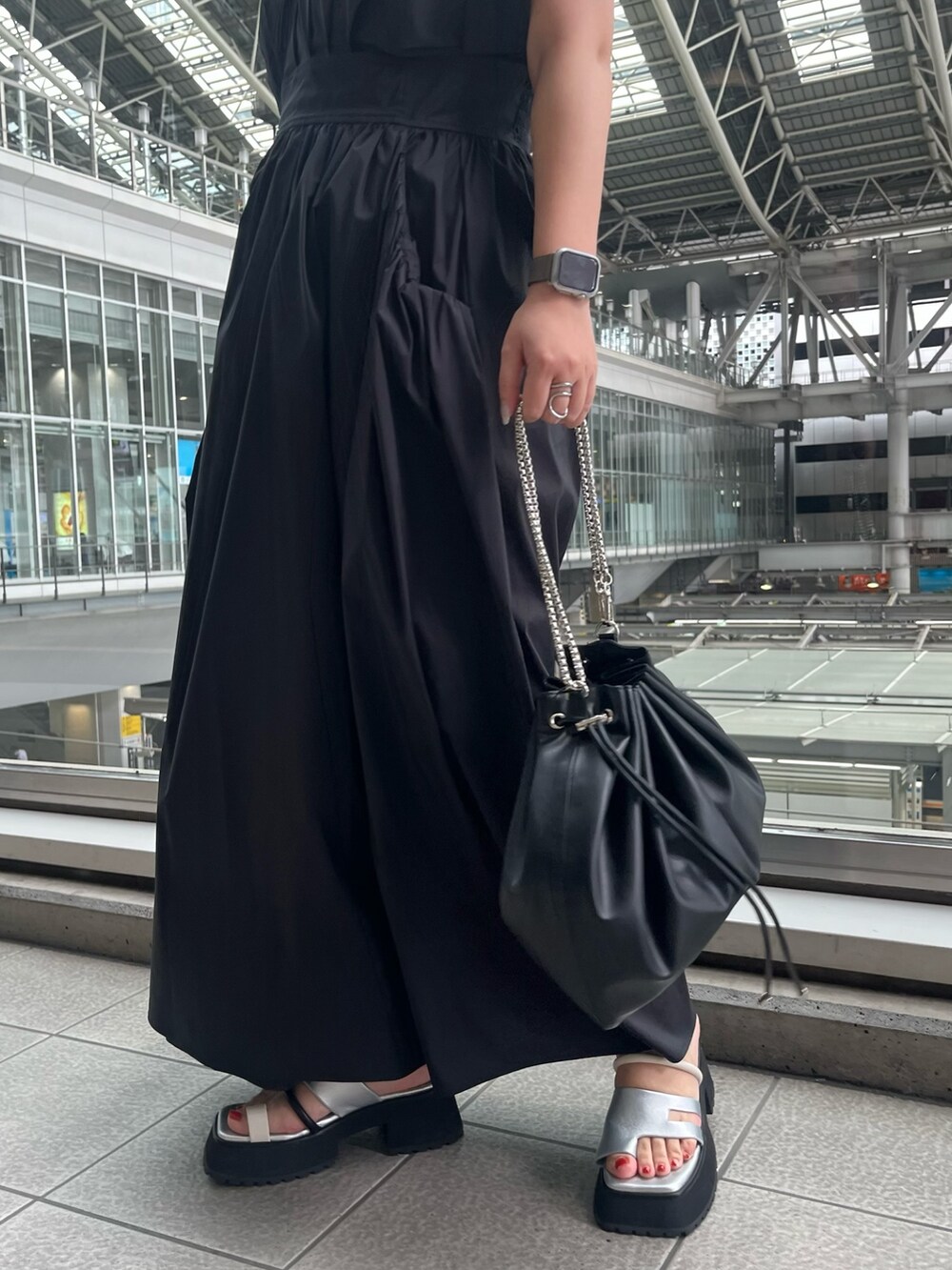 ブラック系のワンピース、ブラック系のショルダーバッグ、その他のサンダルを着用したレディースの春コーディネートの5枚目の写真