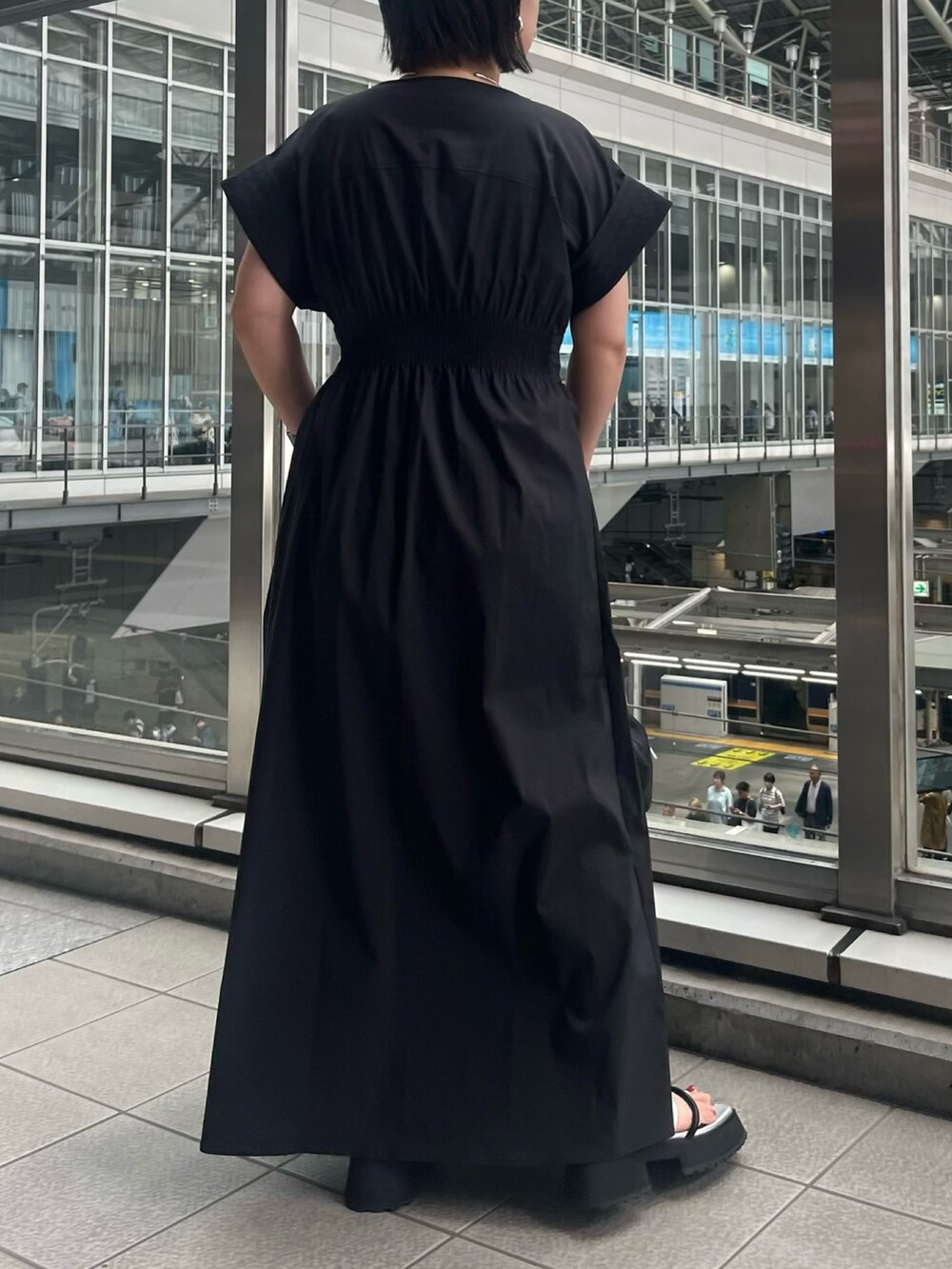 ブラック系のワンピース、ブラック系のショルダーバッグ、その他のサンダルを着用したレディースの春コーディネートの3枚目の写真