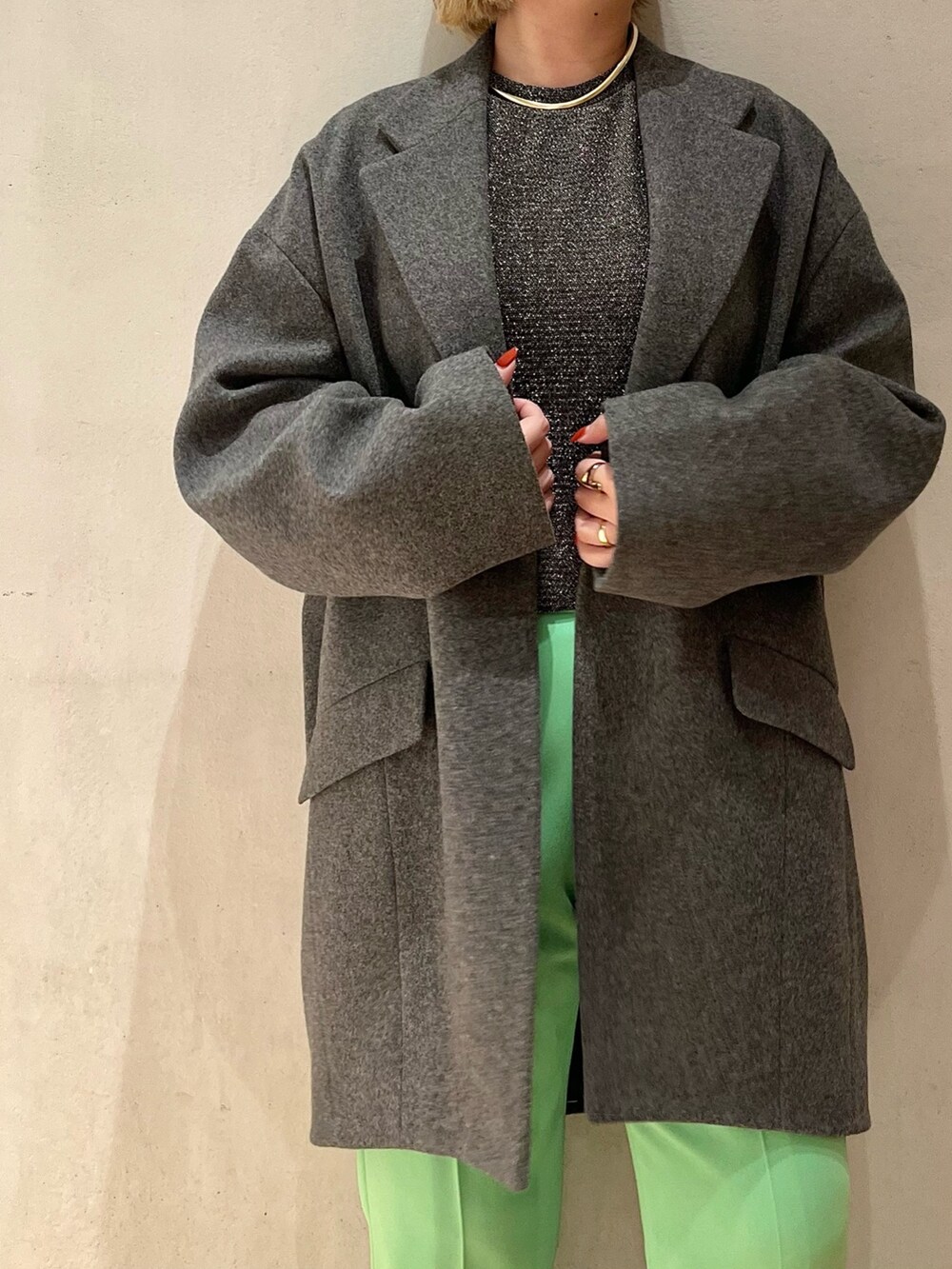 グレー系のチェスターコート、グリーン系のその他パンツ、シルバー系のTシャツ/カットソーを着用したレディースの秋コーディネートの6枚目の写真