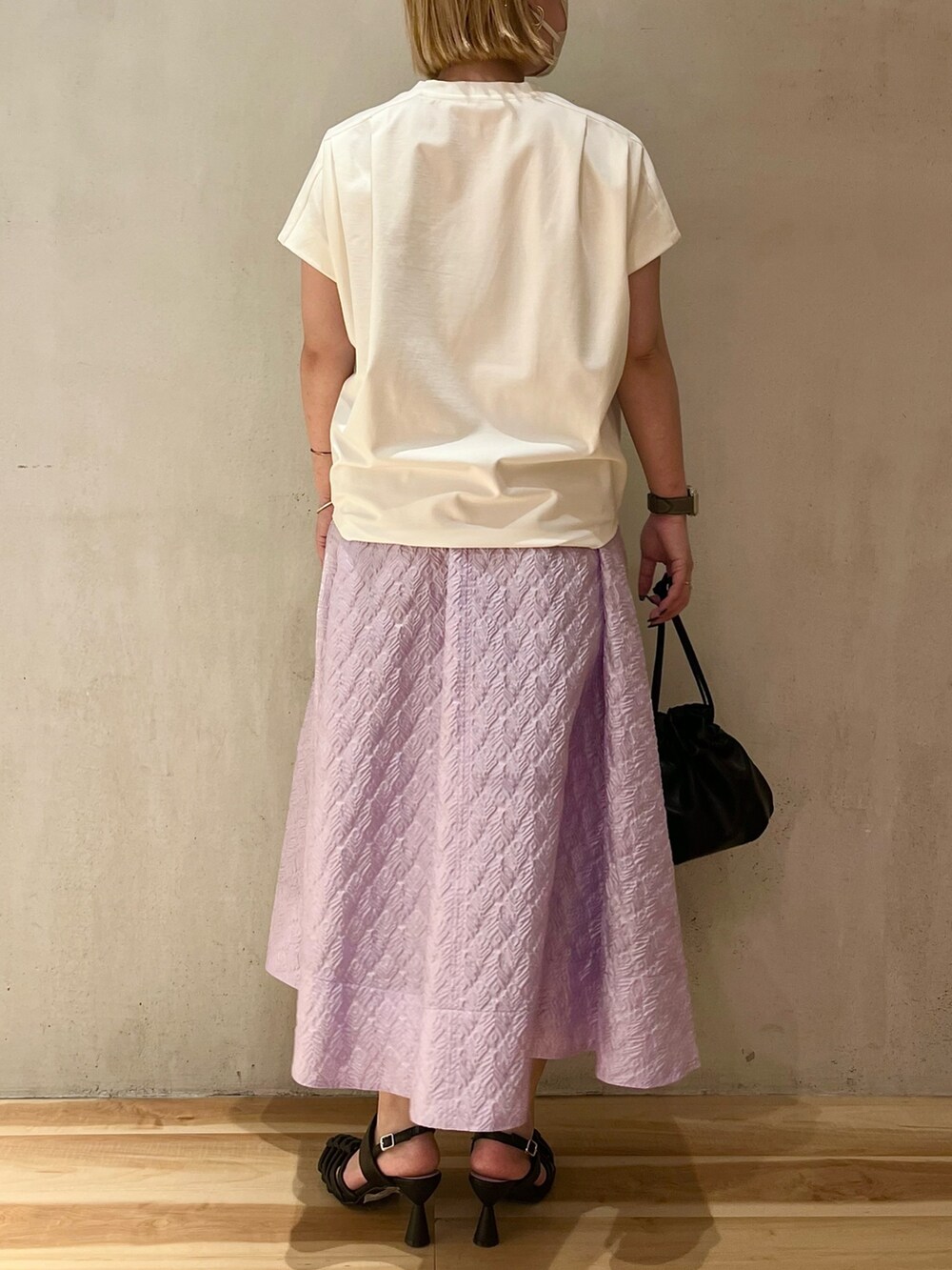 ホワイト系のTシャツ/カットソー、パープル系のスカート、ブラック系のサンダルを着用したレディースの春コーディネートの3枚目の写真