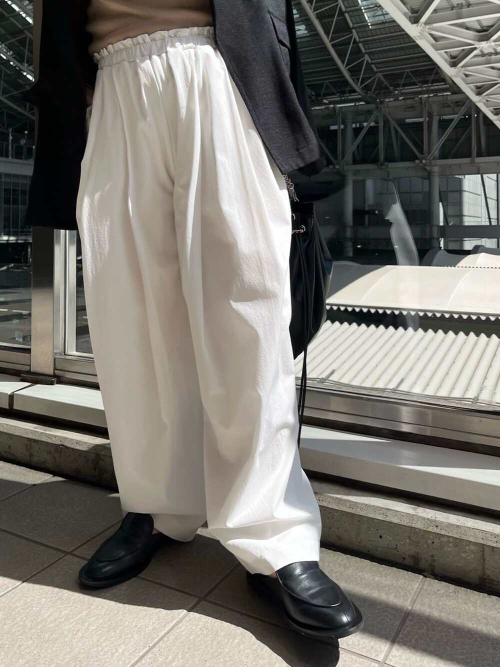 ブラック系のテーラードジャケット、ベージュ系のニット/セーター、ホワイト系のその他パンツを着用したレディースの春コーディネートの7枚目の写真