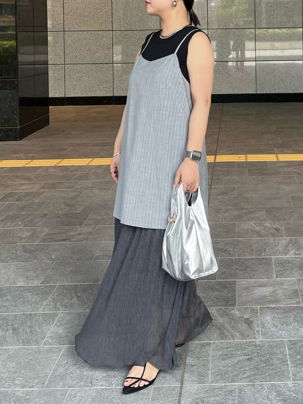 ブラック系のニット/セーター、グレー系のワンピース、シルバー系のハンドバッグを着用したレディースの夏コーディネートの3枚目の写真