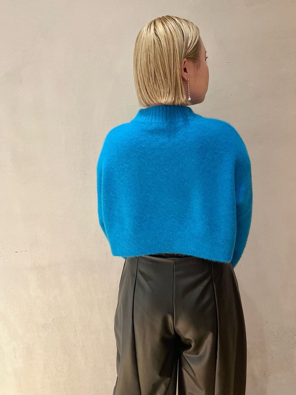 ブルー系のニット/セーター、ブラック系のその他パンツ、ブラック系のブーツを着用したレディースの秋コーディネートの7枚目の写真