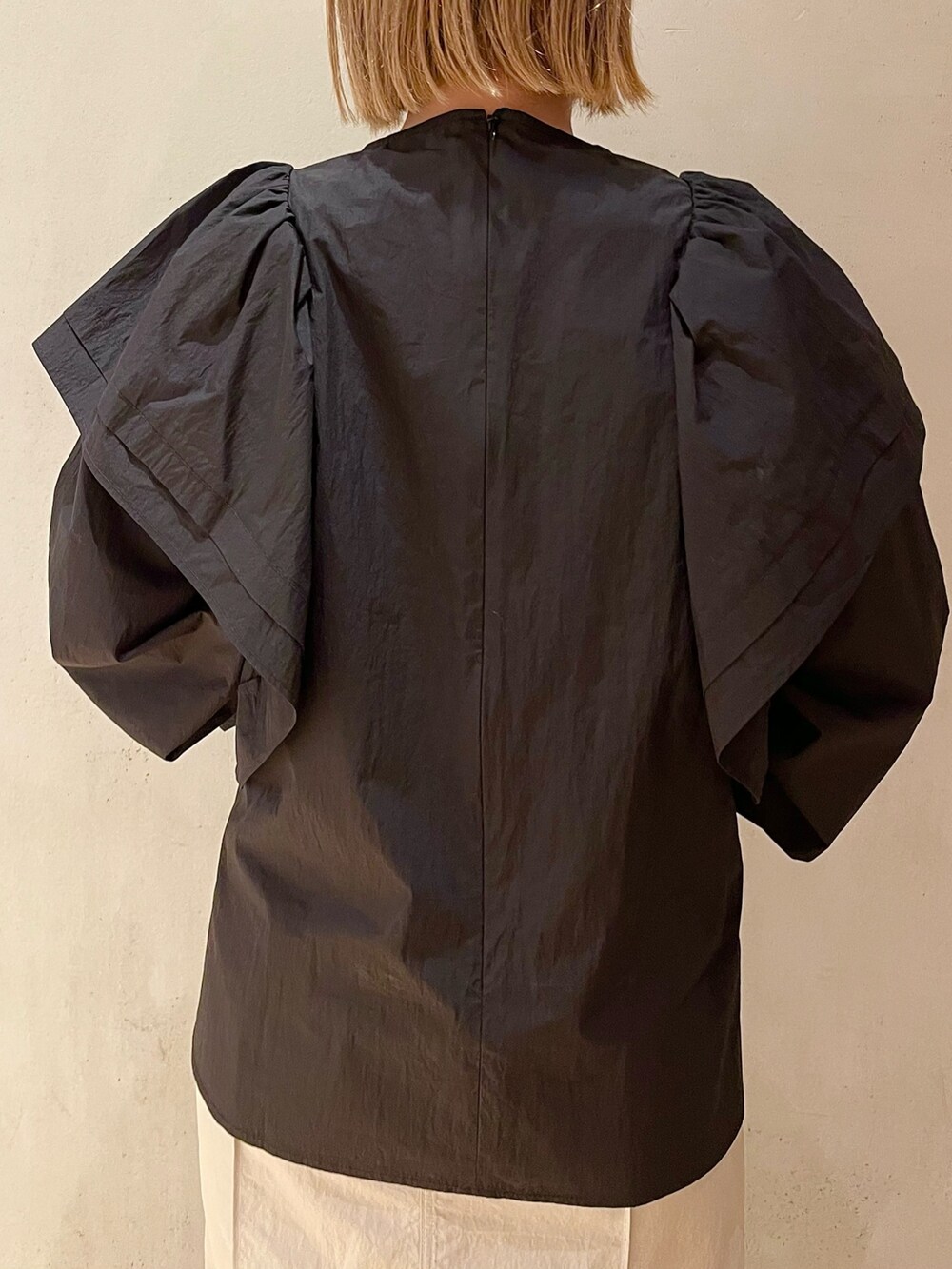 ブラック系のスニーカー、ブラック系のシャツ/ブラウス、ベージュ系のスカートを着用したレディースの冬コーディネートの5枚目の写真