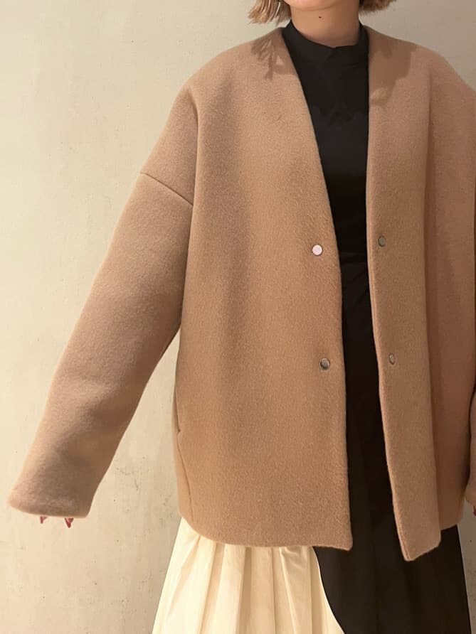 ブラウン系のブーツ、ブラック系のワンピース、イエロー系のノーカラーコートを着用したレディースの秋コーディネートの4枚目の写真