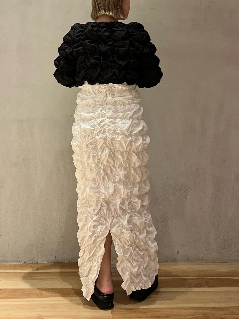 ホワイト系のワンピース、ブラック系のカーディガン/ボレロを着用したレディースの冬コーディネートの5枚目の写真