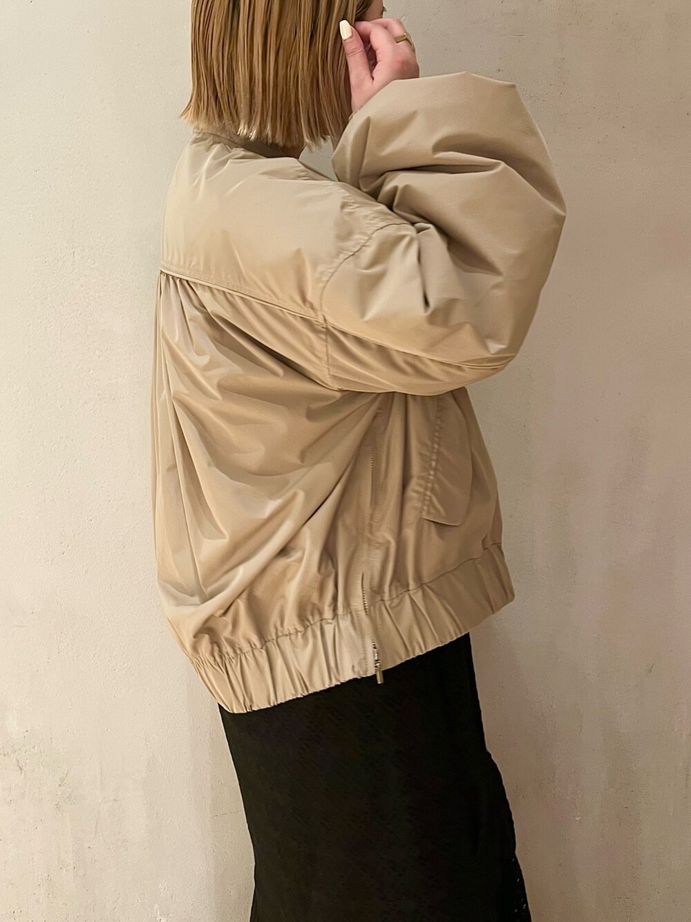 ベージュ系のブルゾン、ブラック系のスニーカー、ブラック系のワンピースを着用したレディースの春コーディネートの5枚目の写真