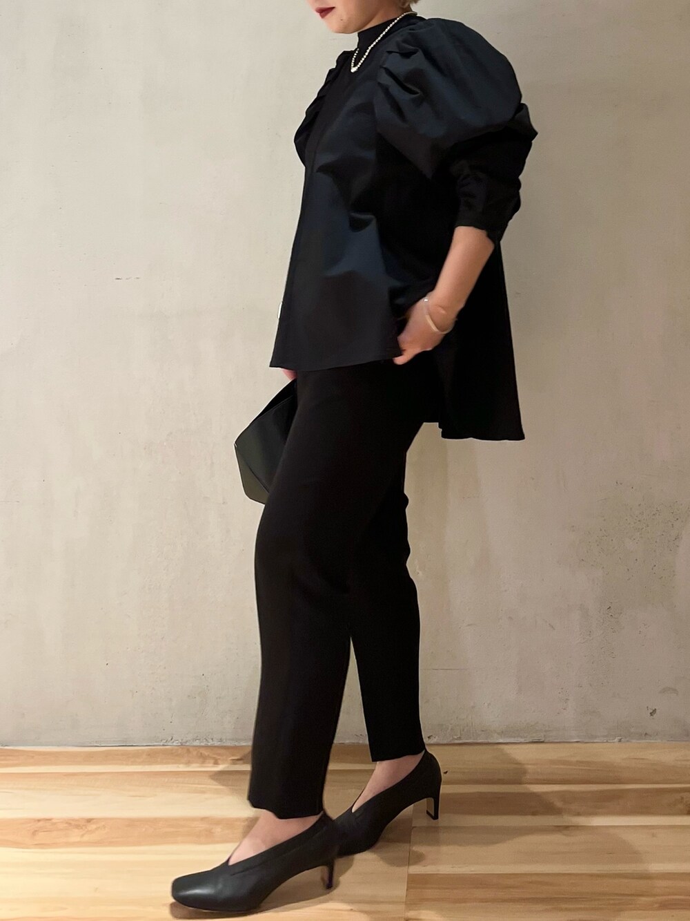 ブラック系のハンドバッグ、ブラック系のその他パンツ、ブラック系のシャツ/ブラウスを着用したレディースの冬コーディネートの2枚目の写真