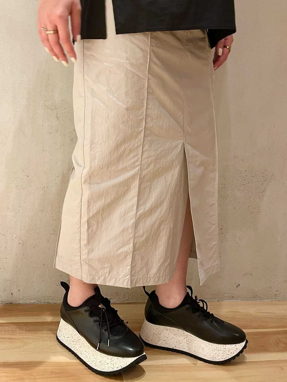 ブラック系のスニーカー、ブラック系のシャツ/ブラウス、ベージュ系のスカートを着用したレディースの冬コーディネートの7枚目の写真