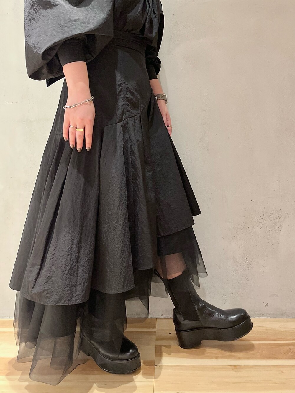 ブラック系のシャツ/ブラウス、ブラック系のスカート、ブラック系のブーツを着用したレディースの秋コーディネートの10枚目の写真