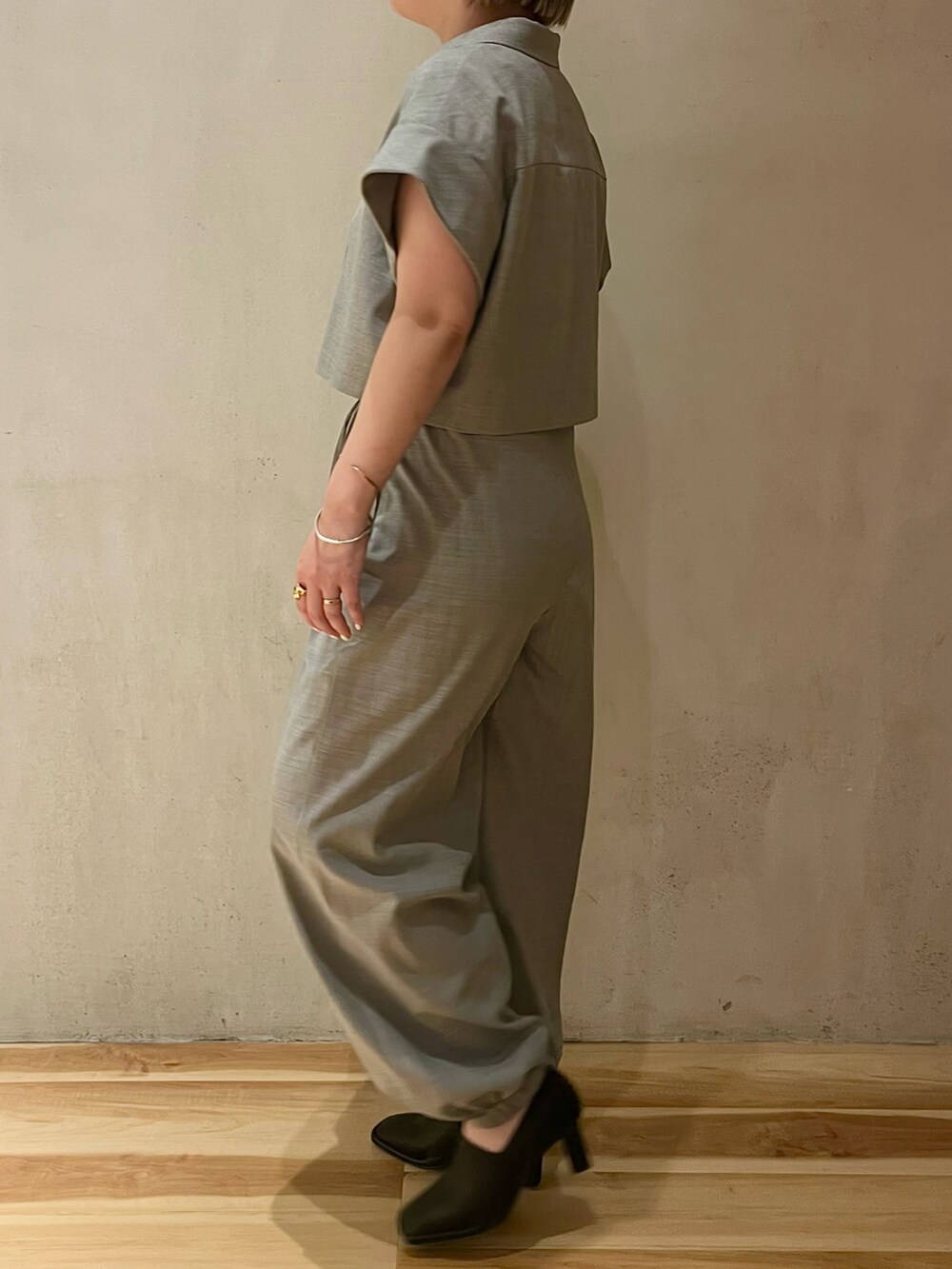 グレー系のテーラードジャケット、グレー系のスラックス、ブラック系のパンプスを着用したレディースの春コーディネートの2枚目の写真