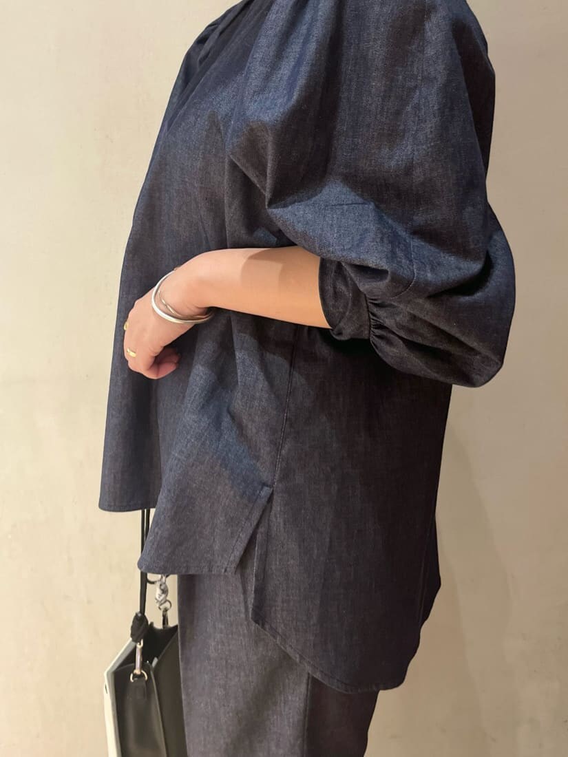 ホワイト系のショルダーバッグ、イエロー系のカーディガン/ボレロ、ブラック系のブーツを着用したレディースの秋コーディネートの7枚目の写真