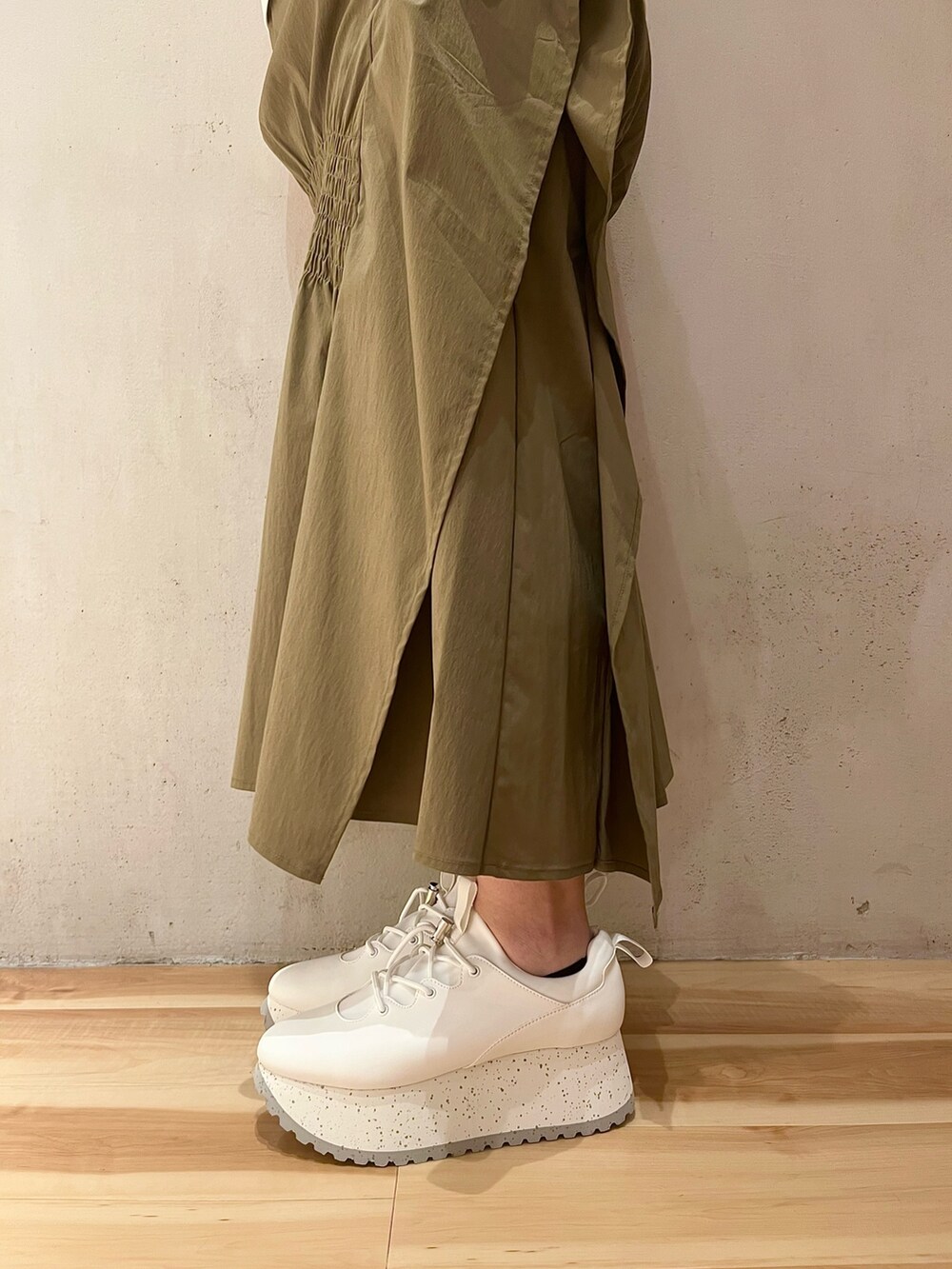 グリーン系のスカート、ホワイト系のTシャツ/カットソー、ホワイト系のスニーカーを着用したレディースの夏コーディネートの9枚目の写真