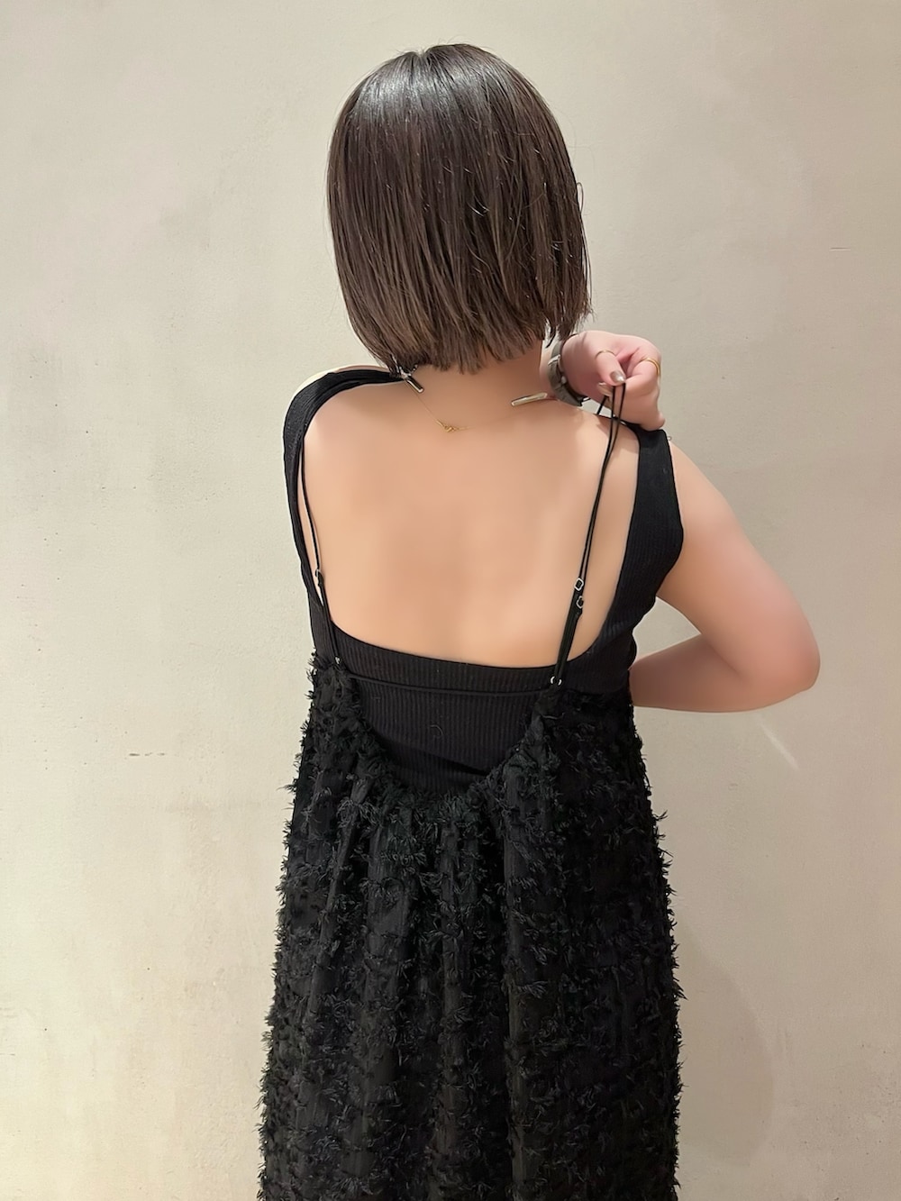 ブラック系のワンピース、ブラック系のタンクトップ、ベージュ系のノーカラーコートを着用したレディースの春コーディネートの9枚目の写真