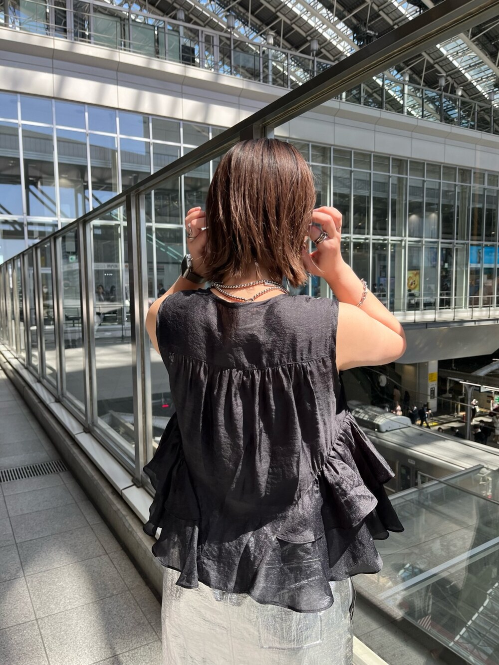 ブラック系のシャツ/ブラウス、シルバー系のスカート、ブラック系のサンダルを着用したレディースの春コーディネートの7枚目の写真