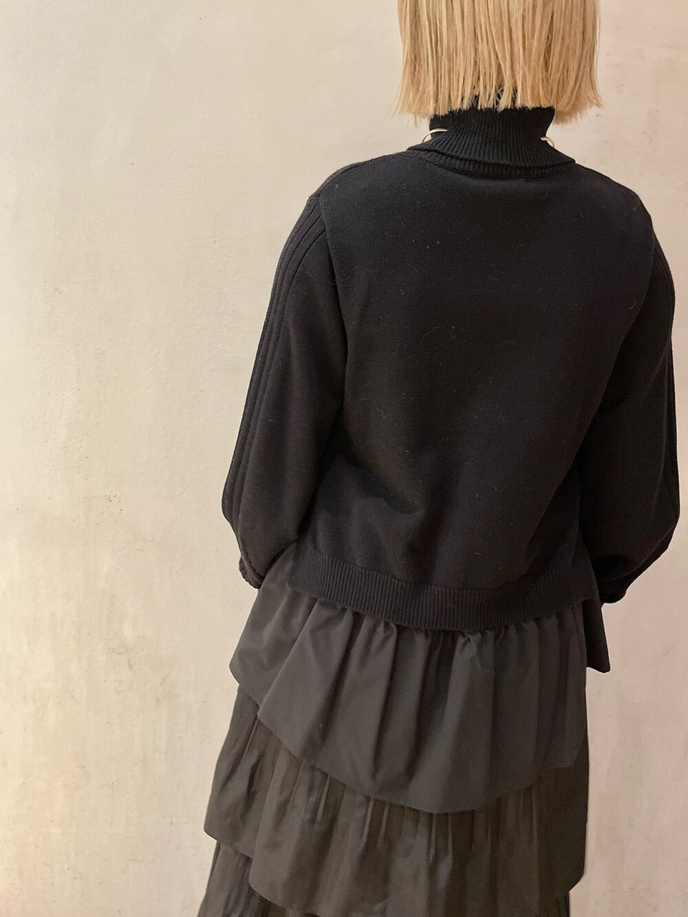 ブラック系のニット/セーター、ブラック系のハンドバッグ、ホワイト系のスカートを着用したレディースの秋コーディネートの8枚目の写真