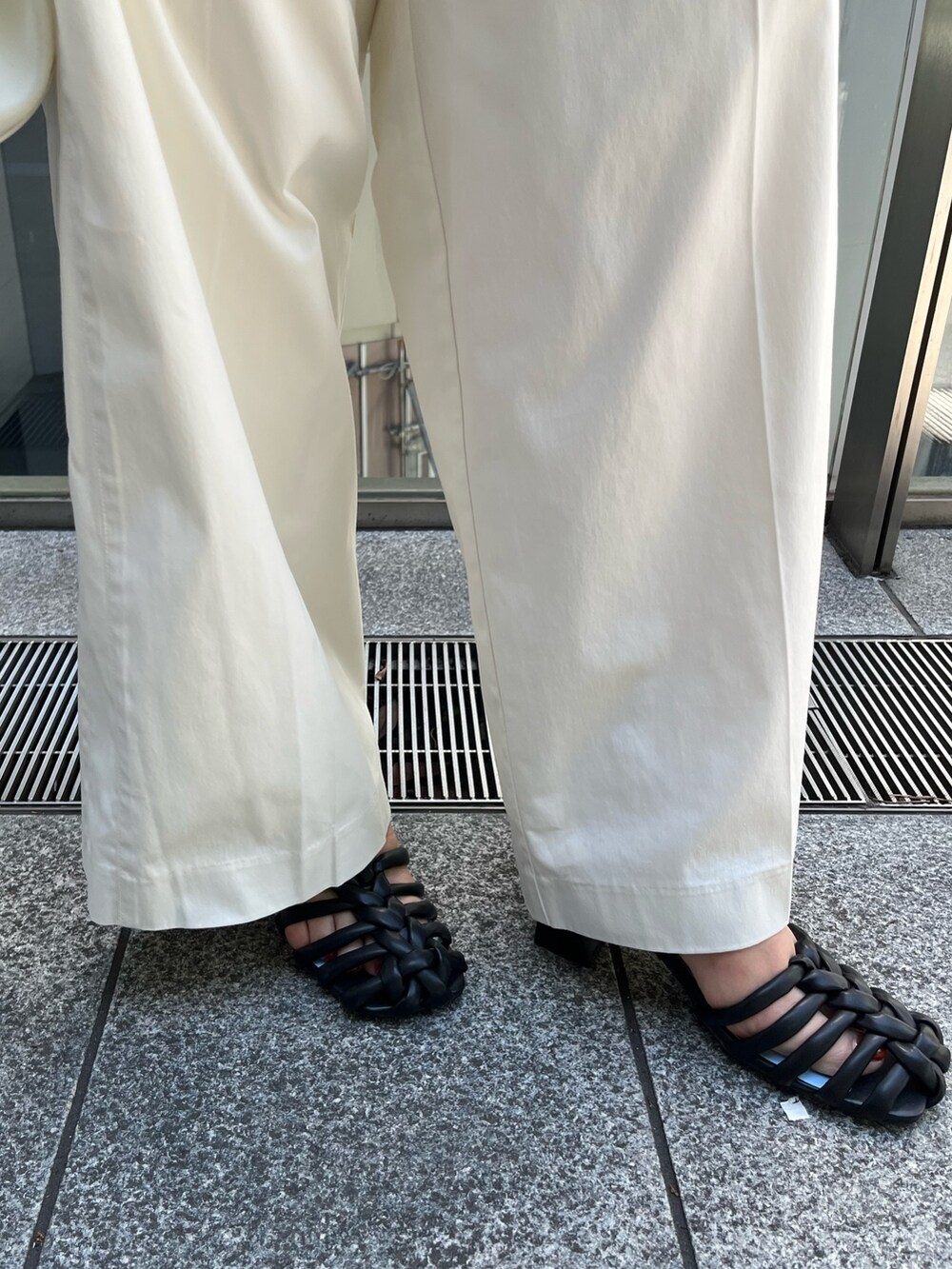 ブラック系のシャツ/ブラウス、ホワイト系のその他パンツ、ブラック系のサンダルを着用したレディースの春コーディネートの9枚目の写真