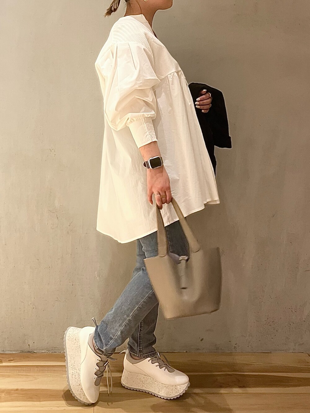 ブラック系のテーラードジャケット、ホワイト系のシャツ/ブラウス、ブルー系のデニムパンツを着用したレディースの冬コーディネートの6枚目の写真