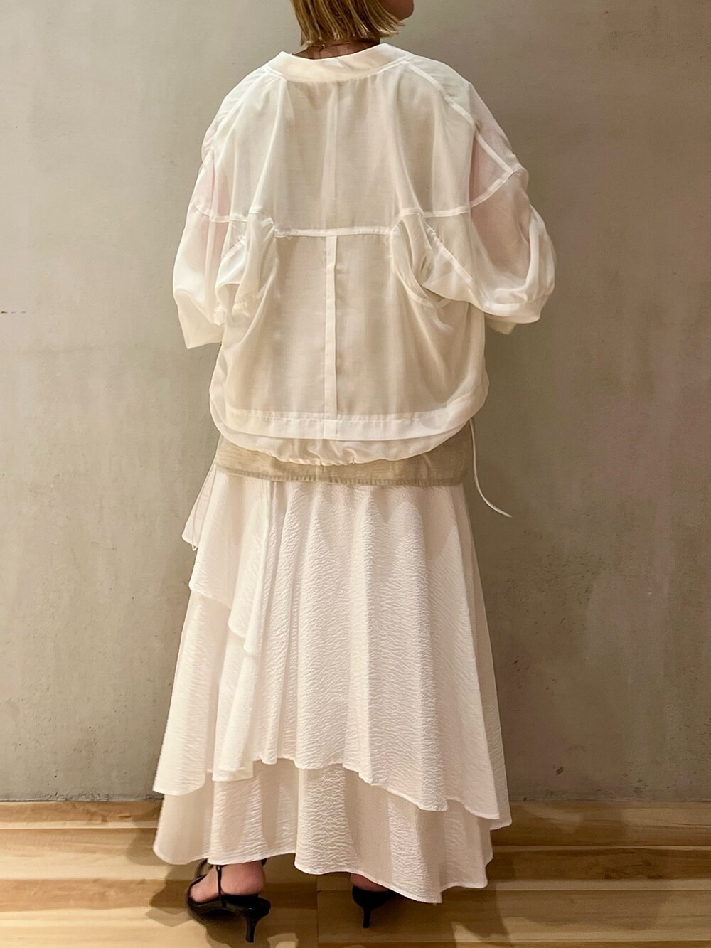 ベージュ系のシャツ/ブラウス、ホワイト系のブルゾン、ゴールド系のネックレスを着用したレディースの夏コーディネートの6枚目の写真