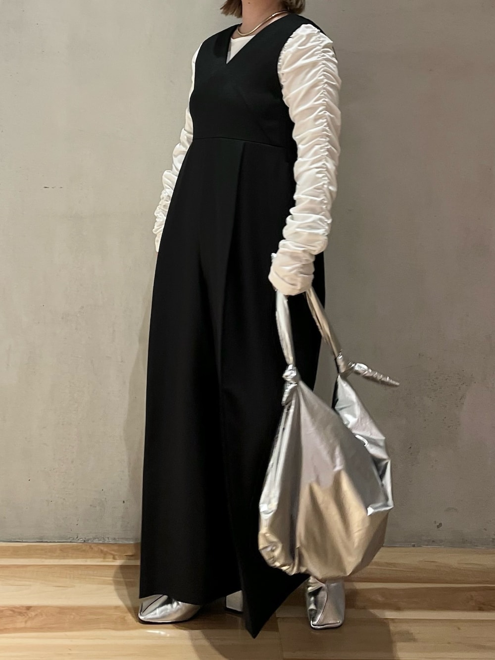 ブラック系のつなぎ/オールインワン、ホワイト系のTシャツ/カットソー、シルバー系のショルダーバッグを着用したレディースの冬コーディネートの2枚目の写真