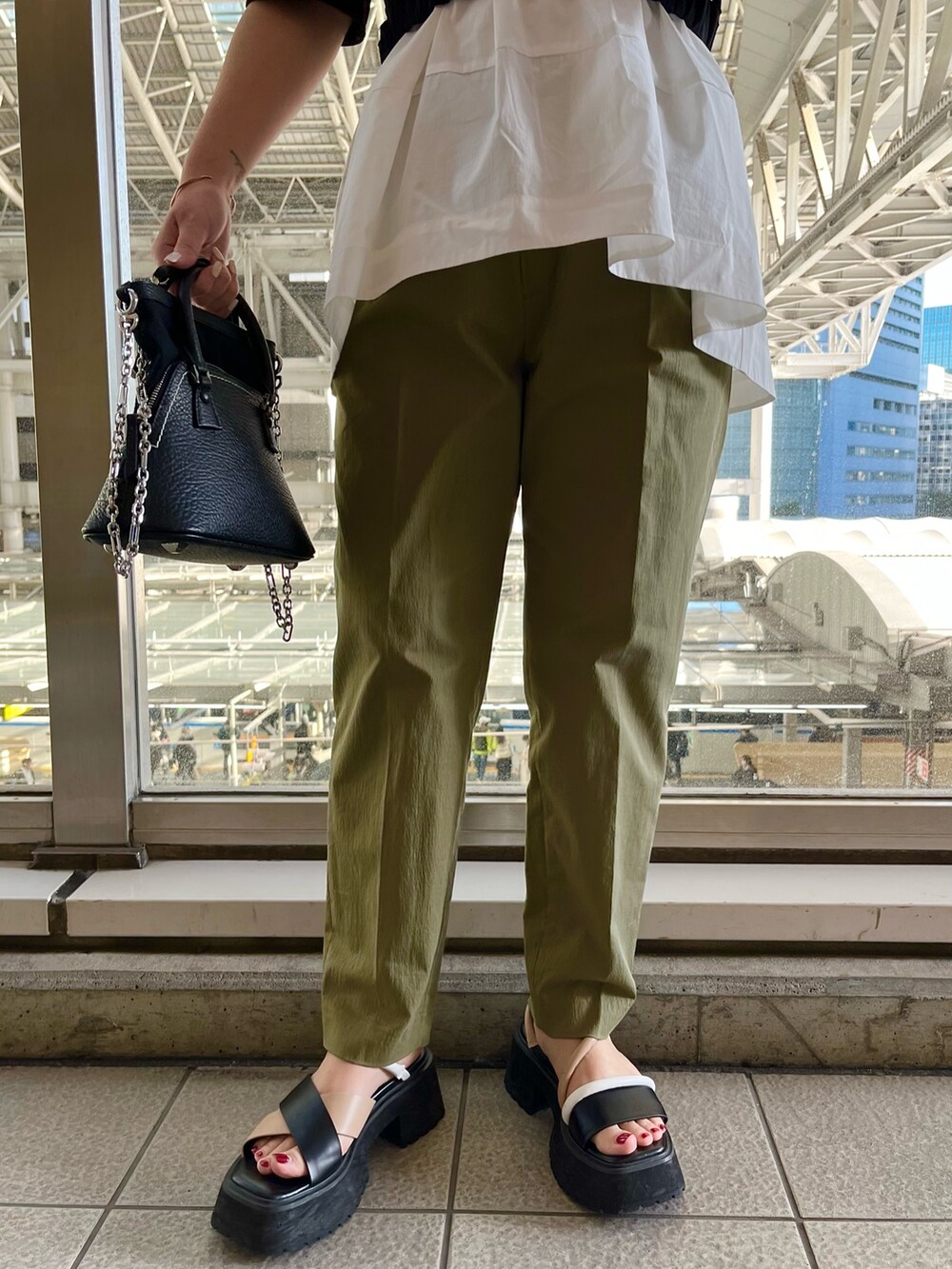 その他のサンダル、グリーン系のその他パンツ、ブラック系のシャツ/ブラウスを着用したレディースの春コーディネートの8枚目の写真