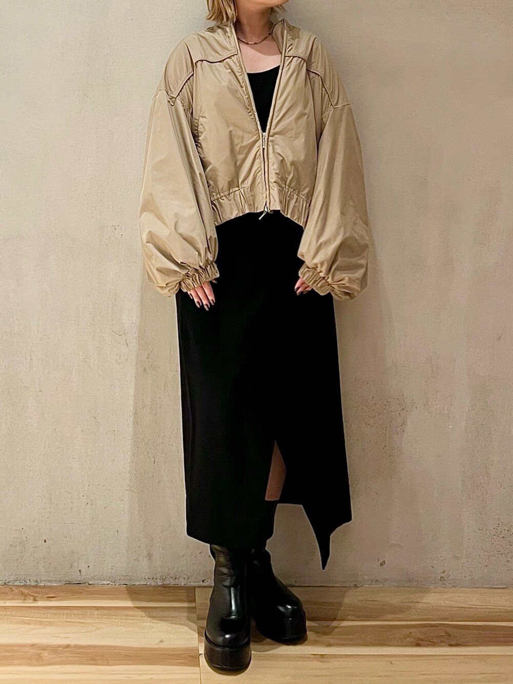 ベージュ系のブルゾン、ブラック系のスカート、ブラック系のブーツを着用したレディースの秋コーディネートの2枚目の写真