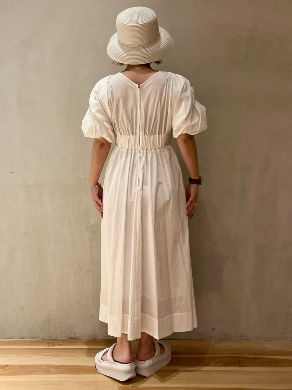 ホワイト系のワンピース、ホワイト系のサンダル、ホワイト系のハットを着用したレディースの春コーディネートの5枚目の写真