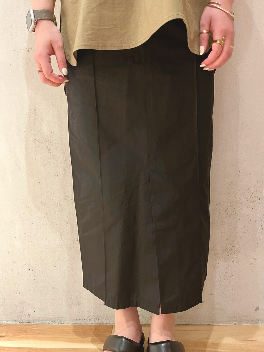 グリーン系のシャツ/ブラウス、ブラック系のスカート、ブラック系のサンダルを着用したレディースの冬コーディネートの8枚目の写真