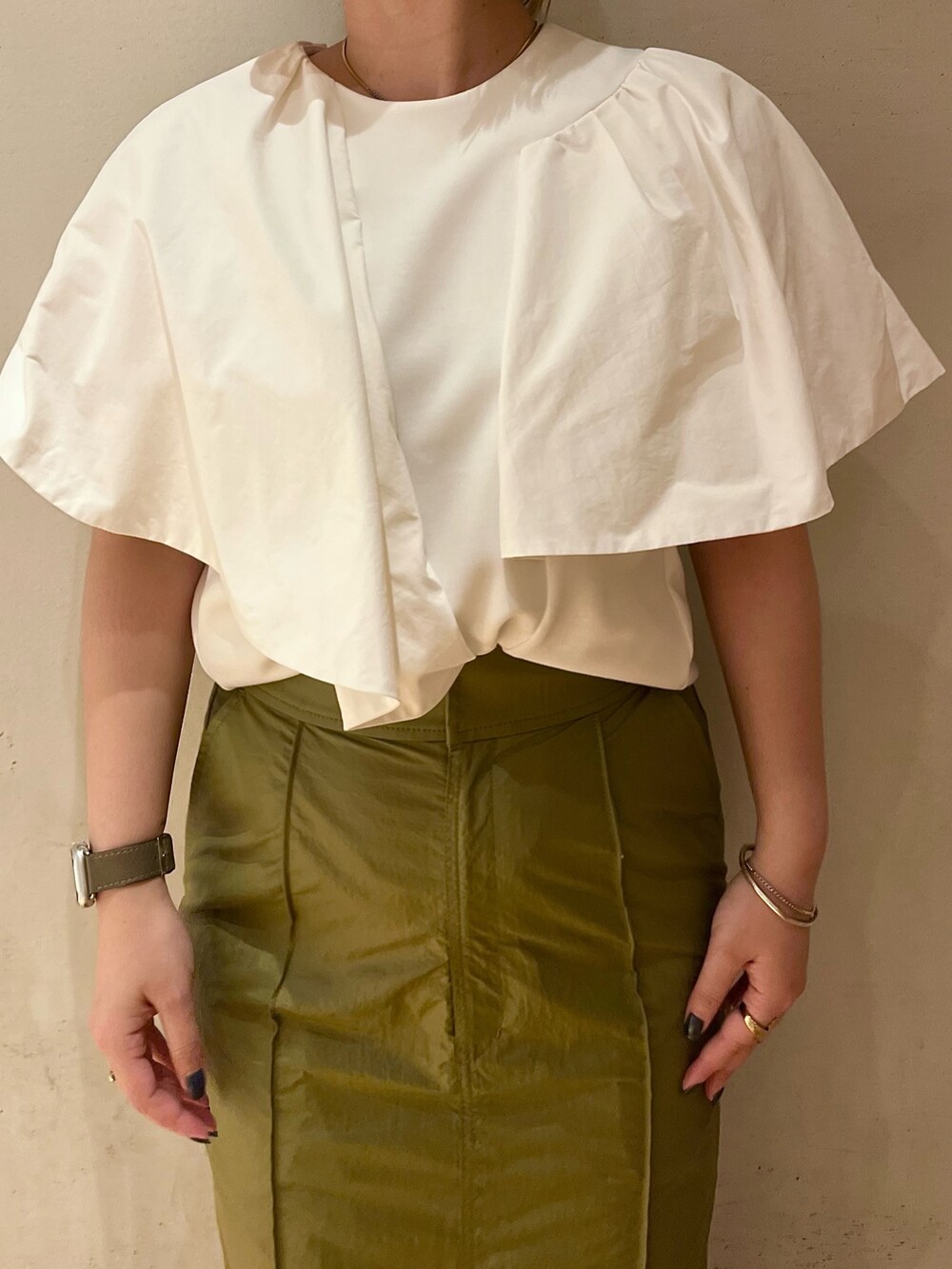 ホワイト系のTシャツ/カットソー、グリーン系のスカート、ブラック系のサンダルを着用したレディースの春コーディネートの5枚目の写真