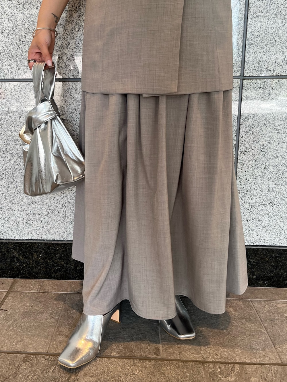 グレー系のワンピース、シルバー系のハンドバッグ、シルバー系のブーツを着用したレディースの夏コーディネートの9枚目の写真