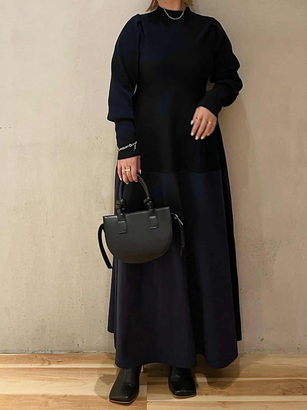 ベージュ系のチェスターコート、ブルー系のワンピース、ブラック系のブーツを着用したレディースの夏コーディネートの8枚目の写真