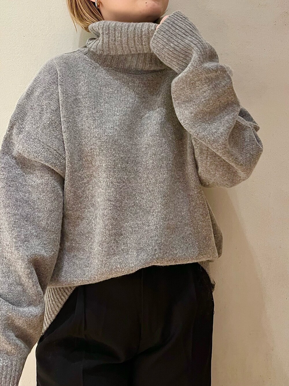 グレー系のニット/セーター、ブラック系のその他パンツ、ブラック系のブーツを着用したレディースの秋コーディネートの6枚目の写真