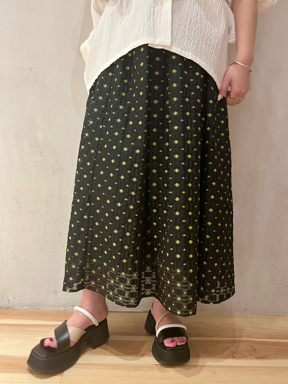 ホワイト系のシャツ/ブラウス、グリーン系のタンクトップ、その他のスカートを着用したレディースの春コーディネートの6枚目の写真