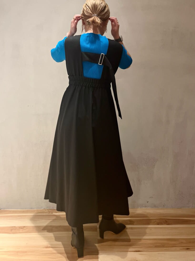 ブルー系のニット/セーター、ブラック系のジャンパースカート、ブラック系のブーツを着用したレディースの夏コーディネートの3枚目の写真