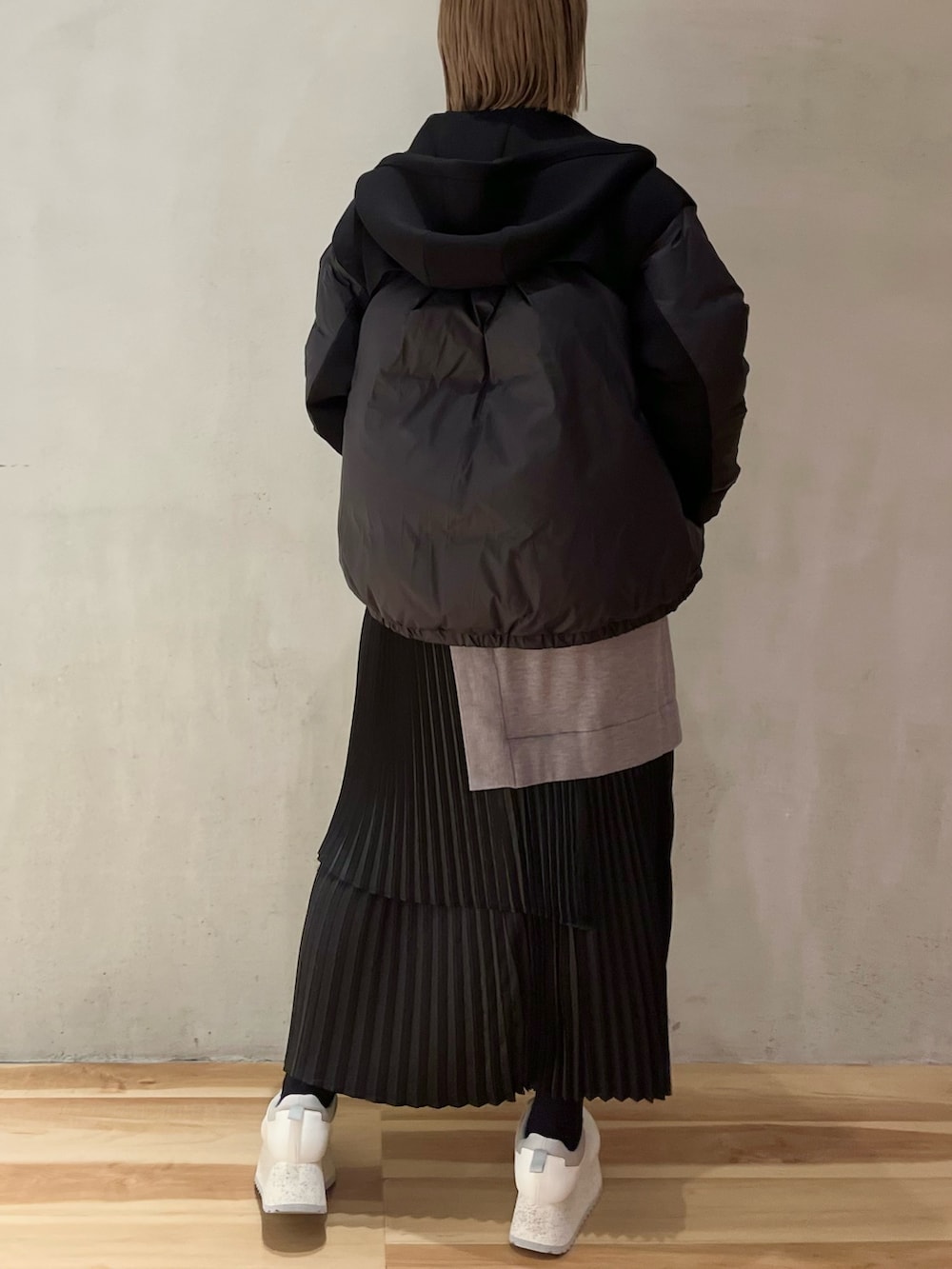 グレー系のワンピース、ホワイト系のスニーカー、ホワイト系のショルダーバッグを着用したレディースの冬コーディネートの3枚目の写真